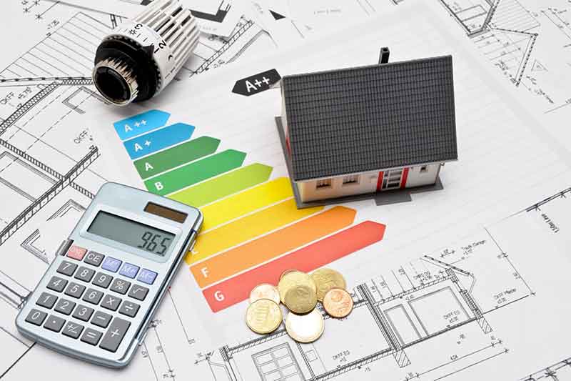 Taschenrechner, Haus und Heizungsgriff auf einem Tisch